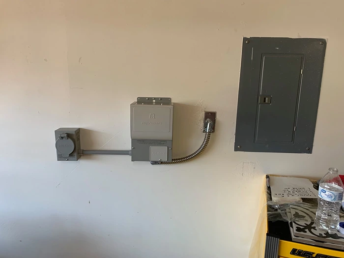 Backup generator inlet box and automatic transfer switch installed next to an electrical panel