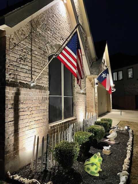 Nighttime uplighting on the brick exterior and entryway of a San Antonio home