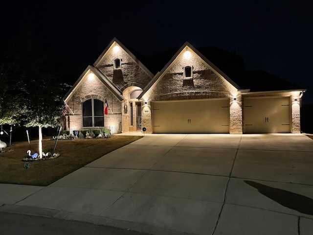 Landscape and soffit lighting illuminating the front exterior of a San Antonio home