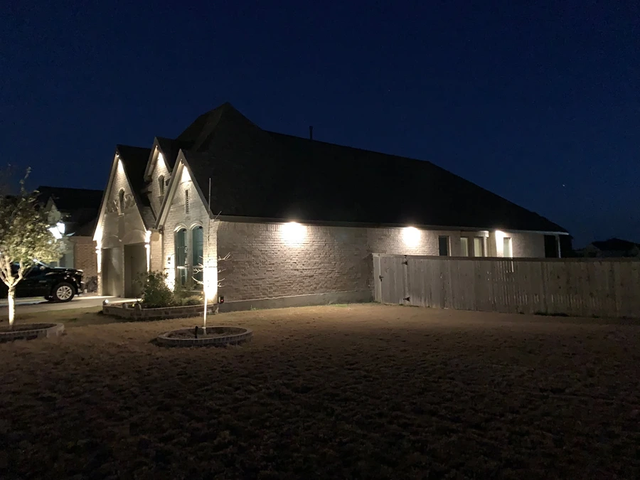 Soft uplighting on the gables and brick exterior of a San Antonio home at night